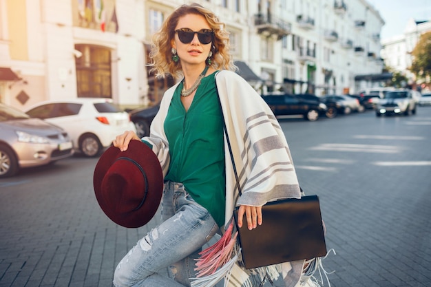 Porträt der jungen attraktiven Frau in Sonnenstrahlen, Straßenartmode, böhmisch elegant