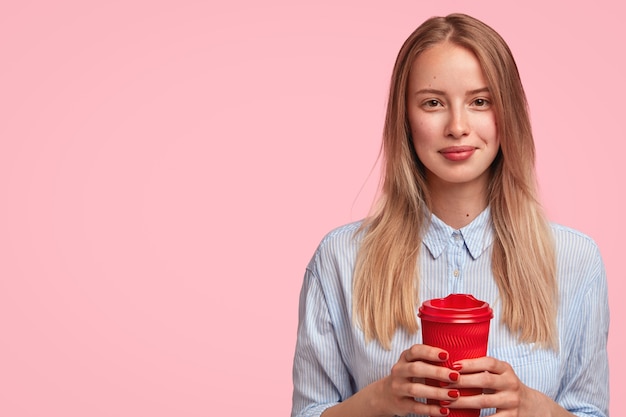 Porträt der jungen blonden Frau, die Tasse Kaffee hält