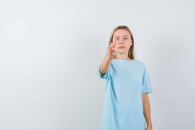 Porträt der jungen Dame, die eine winzige Geste im T-Shirt zeigt