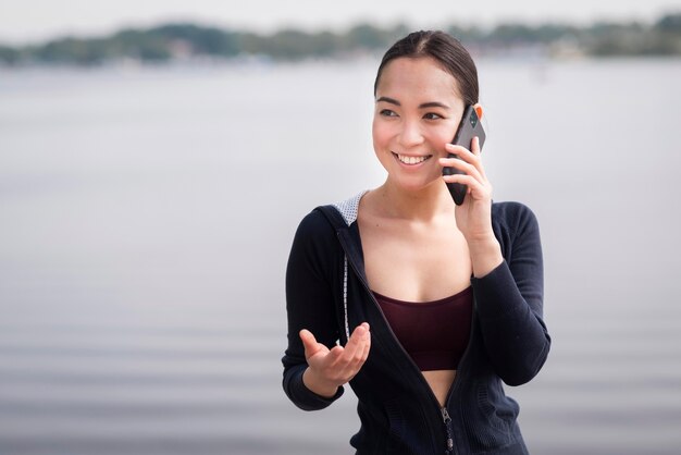 Porträt der jungen Frau, die am Telefon spricht