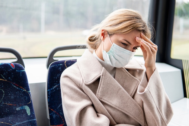 Porträt der jungen Frau, die chirurgische Maske trägt