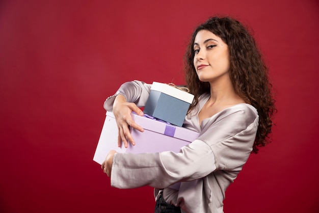 Porträt der jungen Frau, die Geschenkboxen hält.