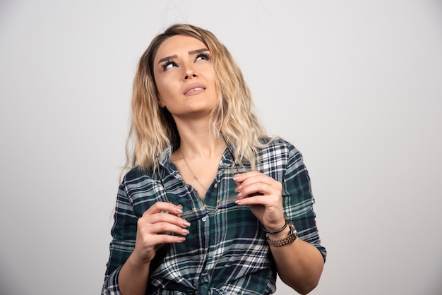 Kostenloses Foto porträt der jungen frau, die mit der stilvollen brille aufwirft.