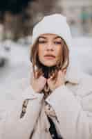 Kostenloses Foto porträt der jungen frau im winteroutfit außerhalb der straße