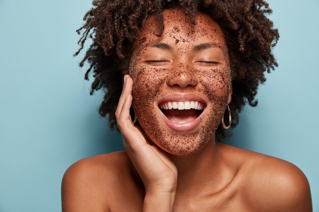 Porträt der jungen Frau mit Afro-Haarschnitt und Gesichtsmaske