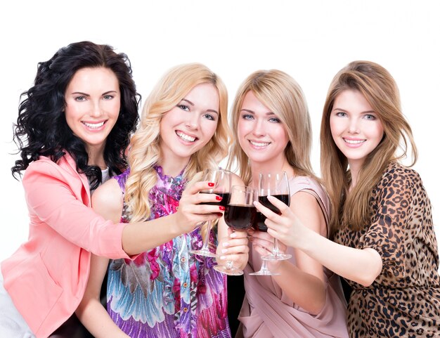 Porträt der jungen glücklichen Frauen, die Spaß haben und Rotwein trinken - lokalisiert auf Weiß