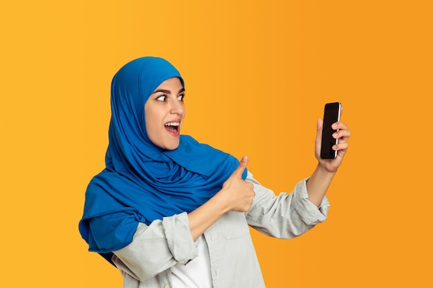 Porträt der jungen muslimischen Frau isoliert auf Gelb