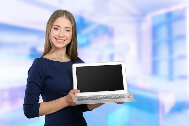 Porträt der jungen schönen brunnete Frau, die Laptop hält