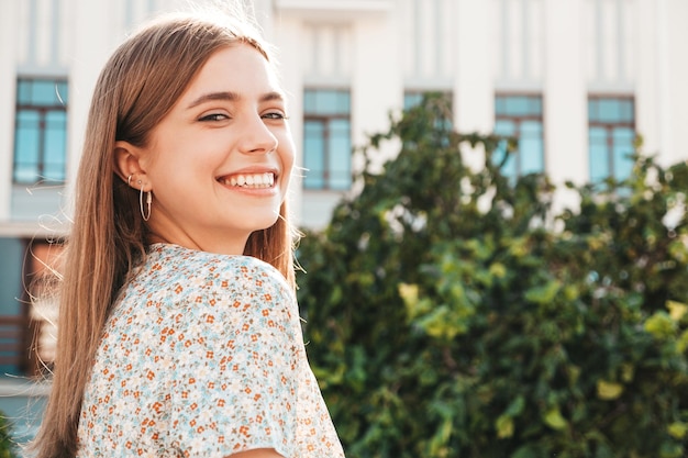 Porträt der jungen schönen lächelnden Hipster-Frau im trendigen Sommerkleid Sexy sorglose Frau, die bei Sonnenuntergang auf dem Straßenhintergrund posiert Positives Modell im Freien Fröhlich und glücklich