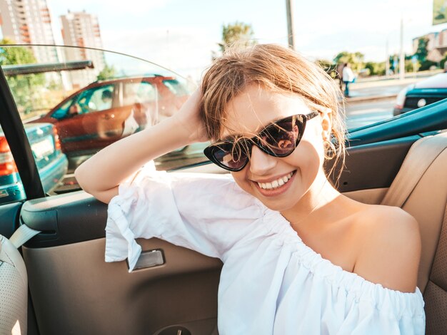 Porträt der jungen schönen und lächelnden Hippie-Frau im Cabrio-Auto