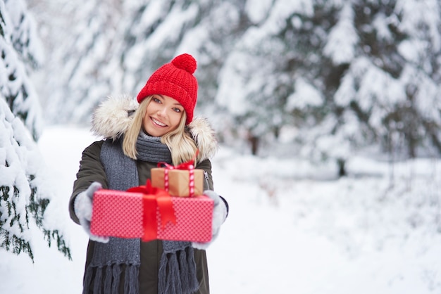 Porträt der lächelnden Frau, die zwei Weihnachtsgeschenke gibt