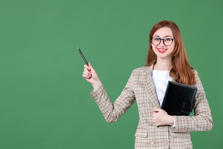 Kostenlose Foto porträt der lehrerin mit notizblock auf grün