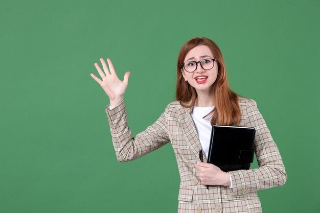 Porträt der Lehrerin mit Notizblock auf Grün