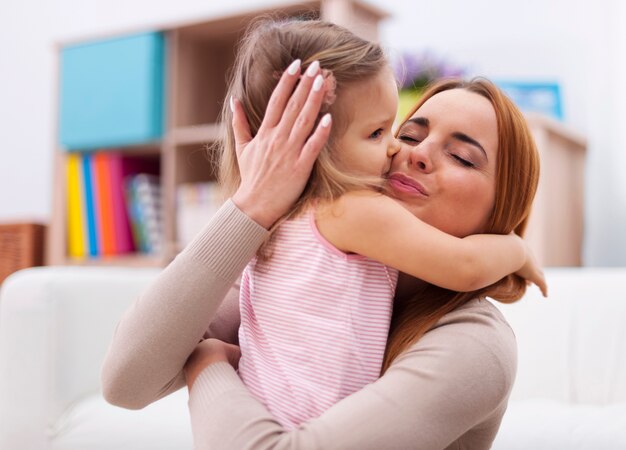 Porträt der liebenden Mutter und Tochter, die zusammen umarmen und küssen