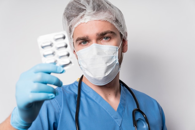 Porträt der männlichen Krankenschwester, die Medizin hält