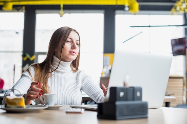 Kostenloses Foto porträt der modernen frau arbeitend mit laptop