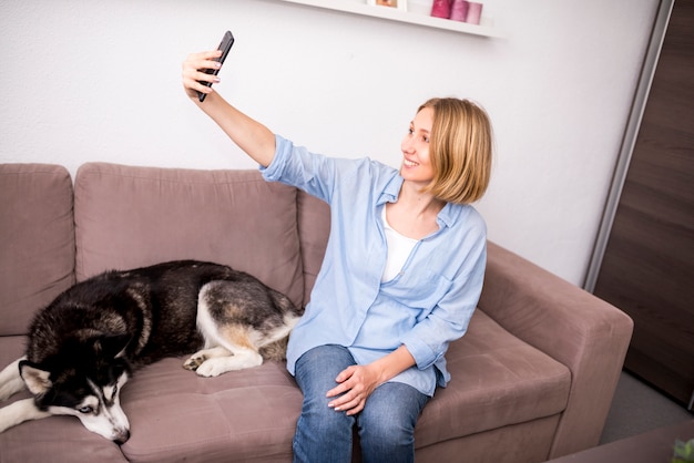 Porträt der modernen Frau zu Hause mit Hund