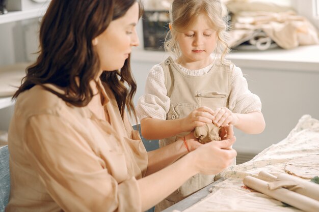 Porträt der Mutter und des kleinen Mädchens, die Ton zusammen formen