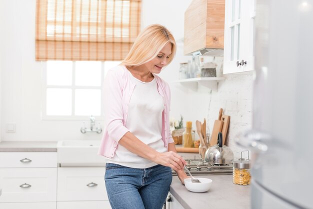 Porträt der netten älteren Frau, die frühstückt