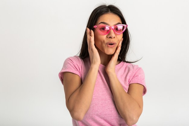 Porträt der niedlichen hübschen lächelnden emotionalen Frau im rosa Hemd und in der stilvollen Sonnenbrille, positive Aufstellung isoliert