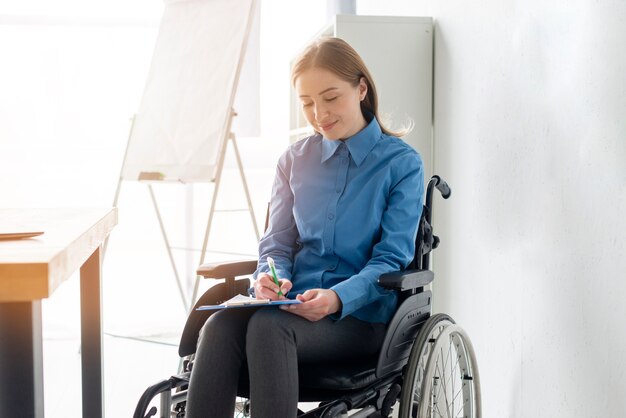 Porträt der positiven erwachsenen Frau, die Notizen macht