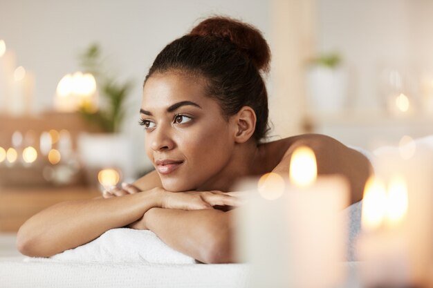 Porträt der schönen afrikanischen Frau, die sich im Spa-Salon entspannt.