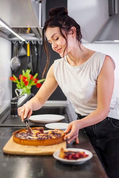 Porträt der schönen Frau, die Kuchen schneidet