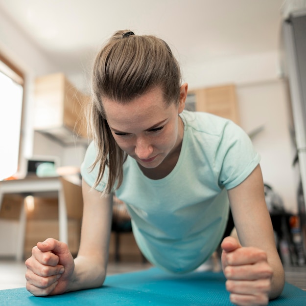 Porträt der schönen Frau, die zu Hause ausübt