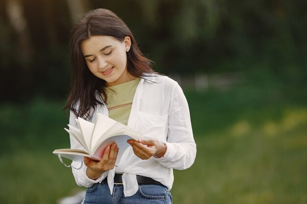 Porträt der schönen Frau. Frau las ein Buch. Dame in einem weißen Hemd.