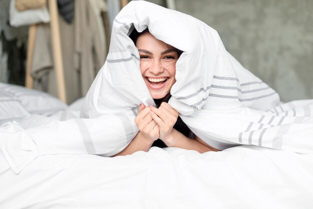 Porträt der schönen Frau glücklich im Bett