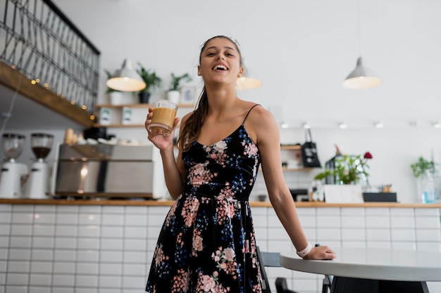 Porträt der schönen jungen Frau, die am Morgen Kaffee trinkt