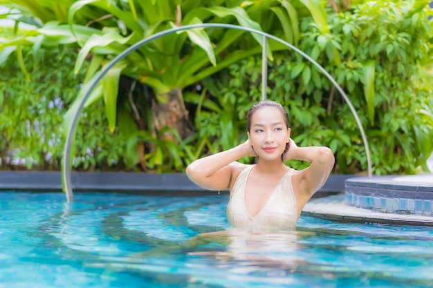 Porträt der schönen jungen Frau, die am Schwimmbad entspannt