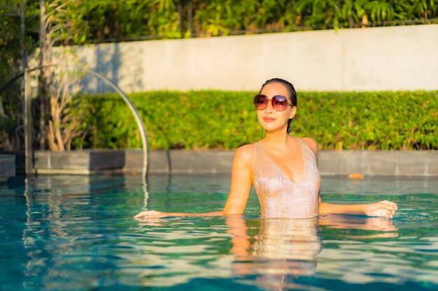 Porträt der schönen jungen Frau, die am Schwimmbad entspannt