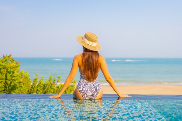 Porträt der schönen jungen Frau, die auf dem Pool entspannt