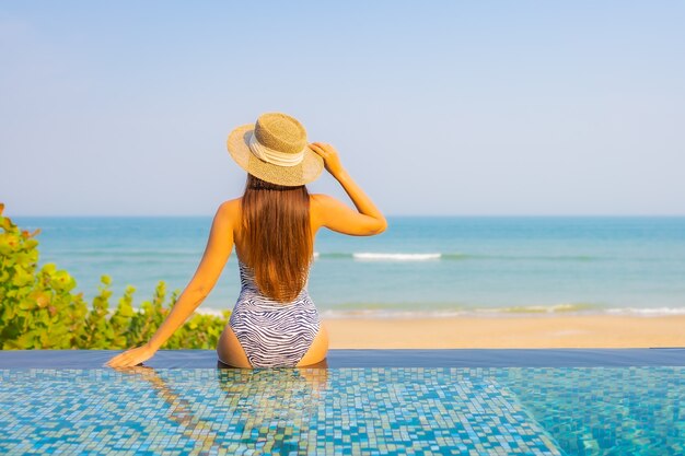 Porträt der schönen jungen Frau, die auf dem Pool entspannt