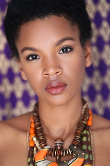 Porträt der schönen jungen schwarzen frau mit traditioneller afrikanischer halskette