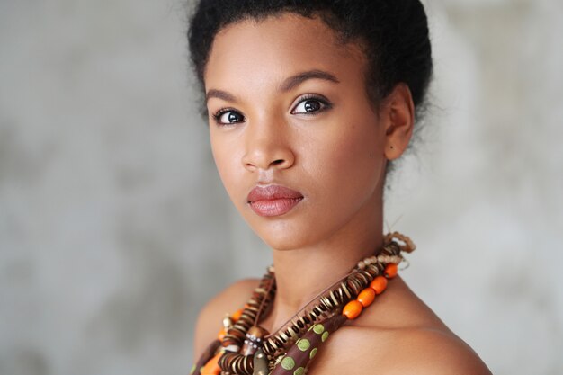 Porträt der schönen jungen schwarzen Frau mit traditioneller afrikanischer Halskette