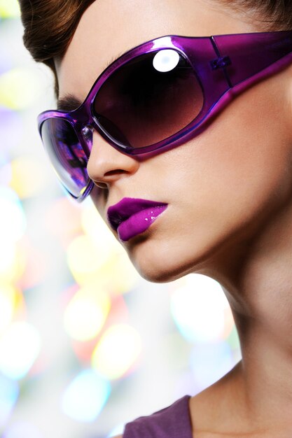 Porträt der schönen stilvollen Frau in der Modeviolett-Sonnenbrille