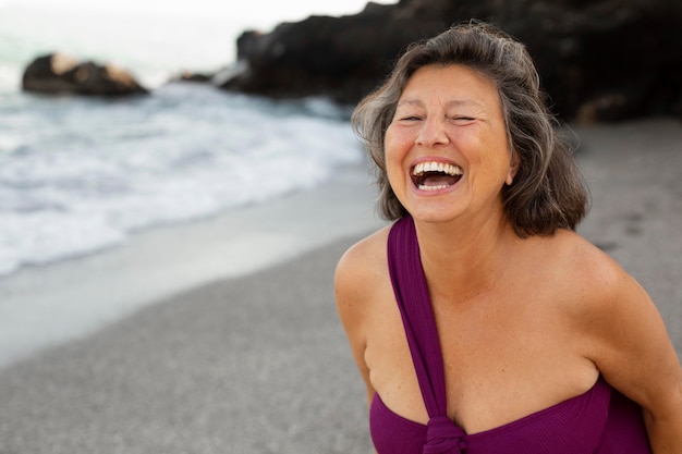 Porträt der Senior-Smiley-Frau am Strand