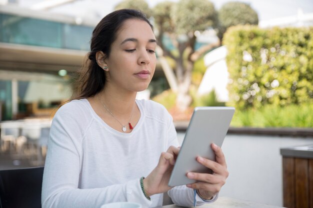 Porträt der starken jungen Frau, die digitale Tablette verwendet