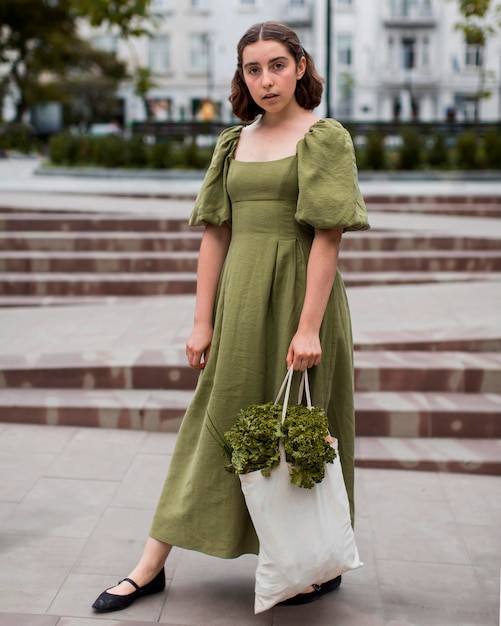 Kostenloses Foto porträt der stilvollen frau, die einkaufstüte trägt