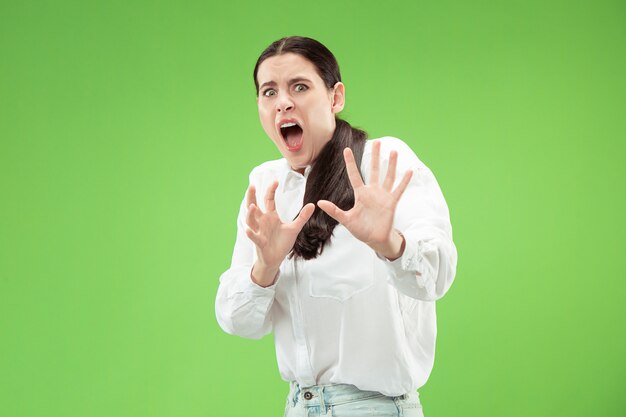 Porträt der verängstigten Frau. Geschäftsfrau, die lokal auf trendiger grüner Wand steht. Weibliches Porträt in halber Länge. Menschliche Emotionen, Gesichtsausdruckkonzept