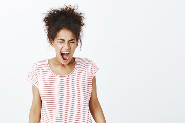 Kostenloses Foto porträt der verärgerten frau mit afro-frisur, die im studio aufwirft