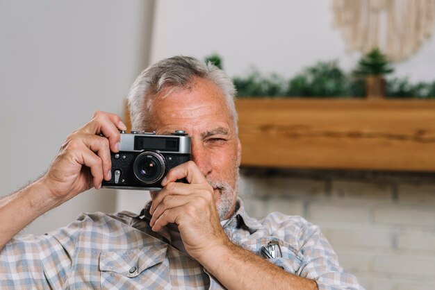 Porträt des älteren Mannes Foto von der Kamera machend