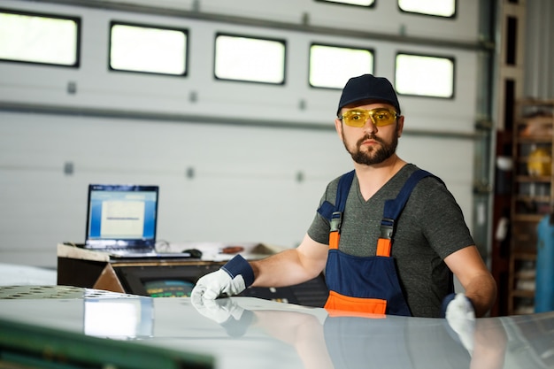 Porträt des arbeiters im overall, hintergrund der stahlfabrik.