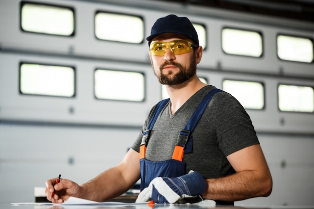 Porträt des Arbeiters im Overall, Hintergrund der Stahlfabrik.