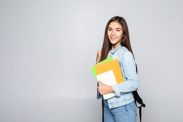 Porträt des attraktiven niedlichen jungen Studentenmädchens lokalisiert auf weißer Wand