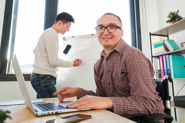 Porträt des behinderten mannes, der im büro arbeitet