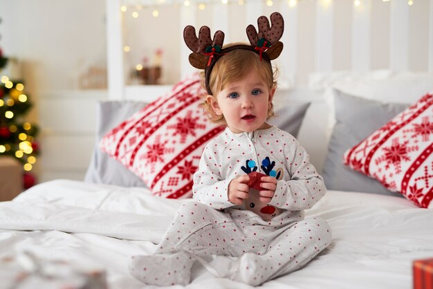 Porträt des charmanten Babys mit Weihnachtsgeschenk