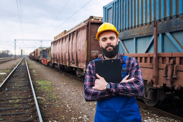 Porträt des Eisenbahnvorarbeiters, der Checkliste hält und Frachtversand kontrolliert